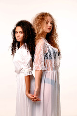 Two beautiful gentle girl in silk peignoir. Afro and blond