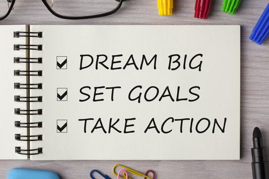 Dream Big, Set Goal, Take Action written in notebook