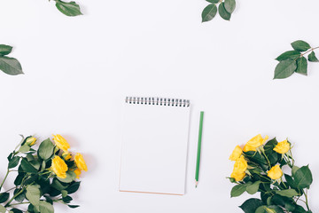 Yellow roses and a notebook with a pencil