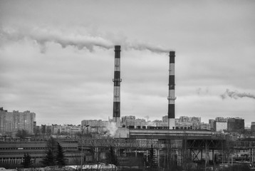 Obraz premium Factory in the city. Environmental pollution threat. Black and white.