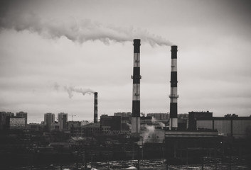 Fototapeta na wymiar Factory in the city. Environmental pollution threat. Black and white.