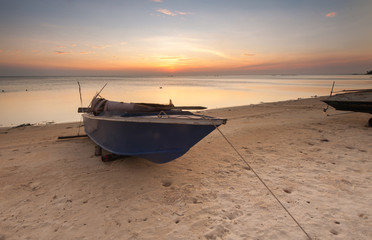 Boat by the beach during sunset.