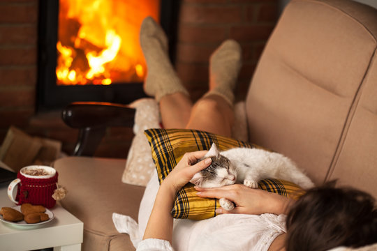 Woman Enjoying The Fire And Some Fine Company - Her Kitten