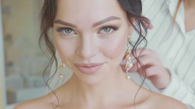 Stylist inserting a veil into the brides hair before the wedding