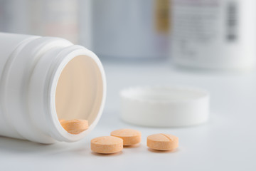 pills spilling out of the white medicine bottle, selective focus
