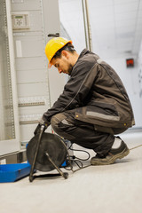 Electrician engineer tests system with relay test set equipment