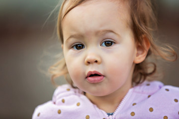 Portrait of a two year old toddler girl playing in the park