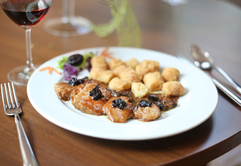 Pork medallions with dried plums and potato croquettes.
