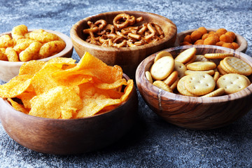 Salty snacks. Pretzels, chips, crackers in wooden bowls.