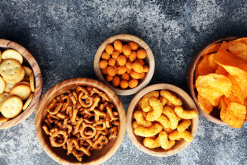 Obraz na płótnie Canvas Salty snacks. Pretzels, chips, crackers in wooden bowls.