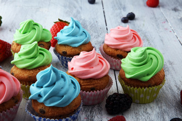 Tasty cupcakes on wooden background. Birthday cupcake in rainbow colors