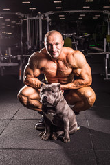 Fototapeta premium bodybuilder posing with dog