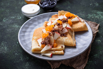 Pancakes crepes with different fruits and chocolate
