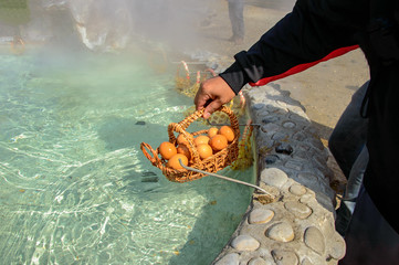 Hot springs eggs in bamboo basket boil in hot water at sankampaeng hot spring Chiang Mai, Thailand.