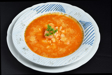Tomato vegetable soup on black background