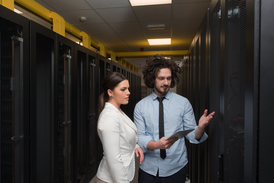 engineer showing working data center server room to female chief