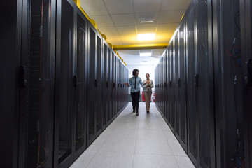 engineer showing working data center server room to female chief