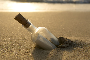 Obraz premium Message in a Bottle Half-Buried in Sand