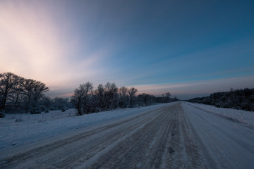 Fototapeta na wymiar Winter road through snowy fields and forests