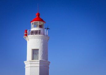 Fototapeta na wymiar White lighthouse on a blue background.
