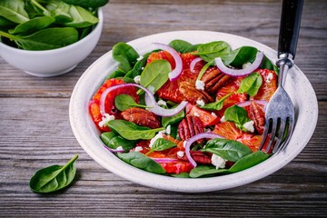 spinach salad with goat cheese, blood oranges, red onions and pecan nuts