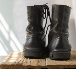Military combat boots on wood plank