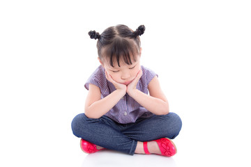 Unhappy little asian girl sitting on the floor isolated over white background