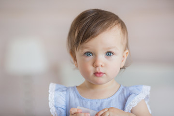 Portrait of a pretty little baby girl in a blue dress