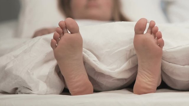 Lady feet in bed itching discomfort, fungus dermatology problem, medical care