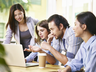 Business people meeting in an office using a laptop
