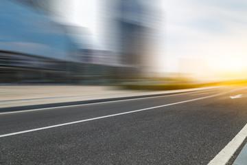 blurred empty urban road and modern buildings at a sunny day, shanghai, china.