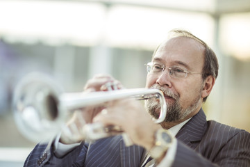 portrait of a musician with a pipe on a light background