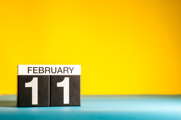 February 11th. Day 11 of february month, calendar on yellow background. Winter time. Empty space...