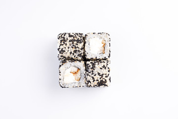 Sushi rolls with eel and cream cheese in black and white sesame top view.
