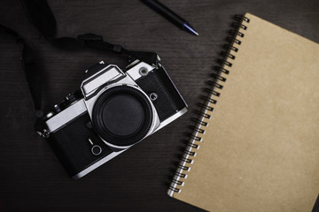Vintage camera and notebook on wood background. 