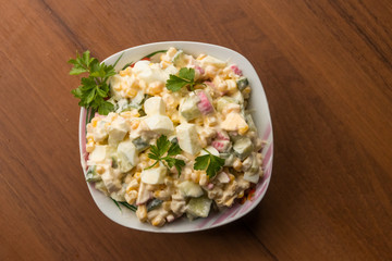 Salad with crab sticks, sweet corn, cucumber, eggs and mayonnaise