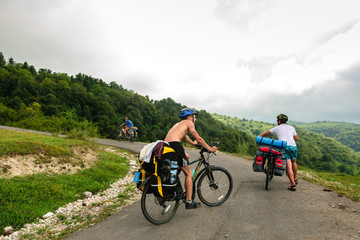 Obraz premium Bicyclists on the asphalt road in Abkhazia