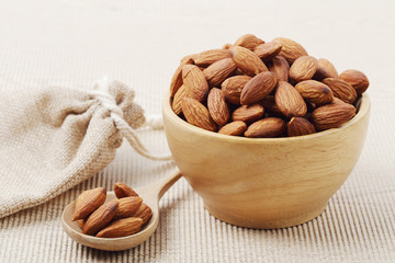 almonds nuts in a wooden bowl over corrugated paper