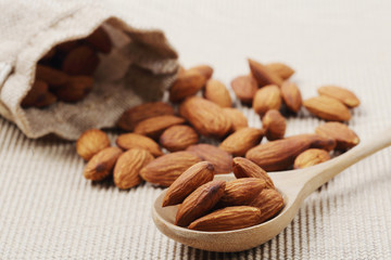 almonds nuts in a wooden spoon over corrugated paper