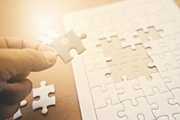 Fototapeta premium Hand holding a piece of jigsaw.