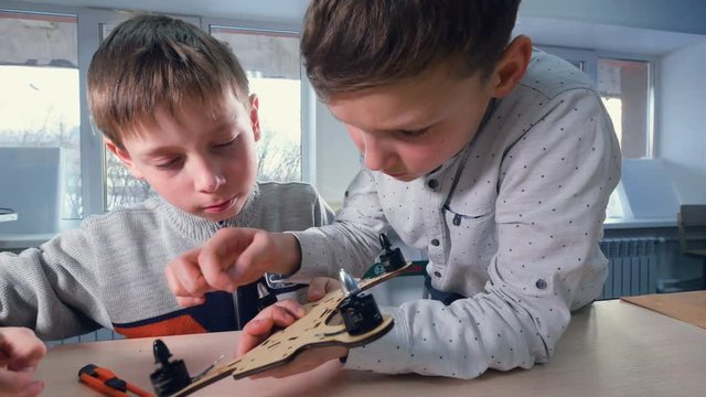 Two boys are finishing their wooden drone model