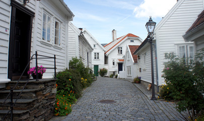 Scenic view of street with traditional white wooden houses in Gamle Stavanger in Rogaland, Norway, sunny day