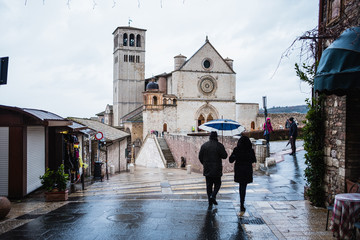 ASSISI, ITALY - 27 December 2017 - The Basilica di San Francesco d Assisi, in Tuscany with tourists and Rain