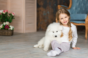 Little girl with a samoyed puppy