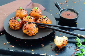Spicy chicken balls in sweet chilli glaze on a metal tray