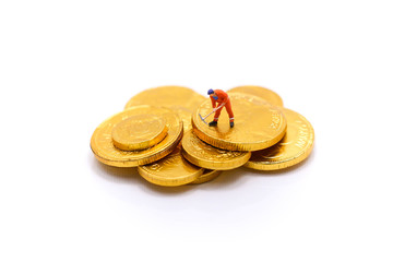 Miniature people :  man worker stand on gold coins, business concept.