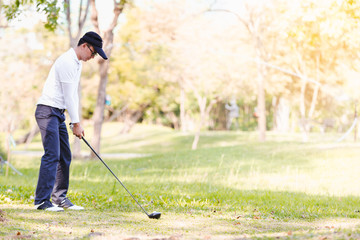 Fototapeta na wymiar Asian men playing golf. men play golf while standing on field