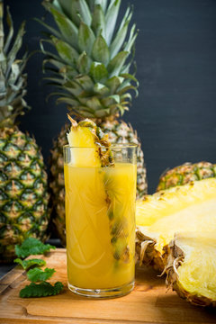 Glass of pineapple juice on the rustic background. Selective focus.