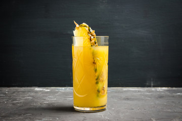 Glass of pineapple juice on the rustic background. Selective focus.