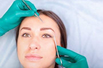 Cosmetic surgeon examining female client in clinik  before plastic surgery. Blepharoplasty